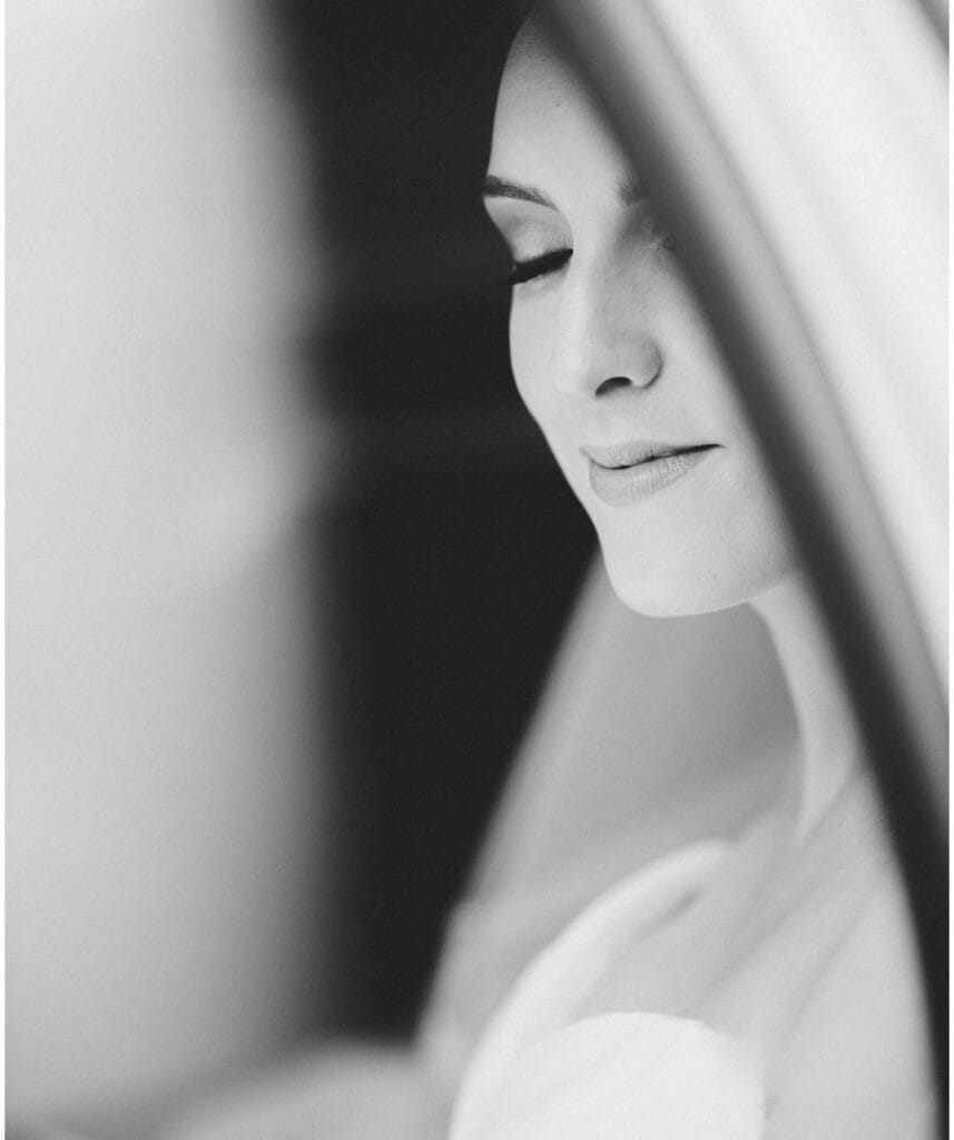 Black and white close-up of a bride with closed eyes, captured by a York editorial photographer. Her expression is serene and content, and the soft focus creates an ethereal, intimate atmosphere.